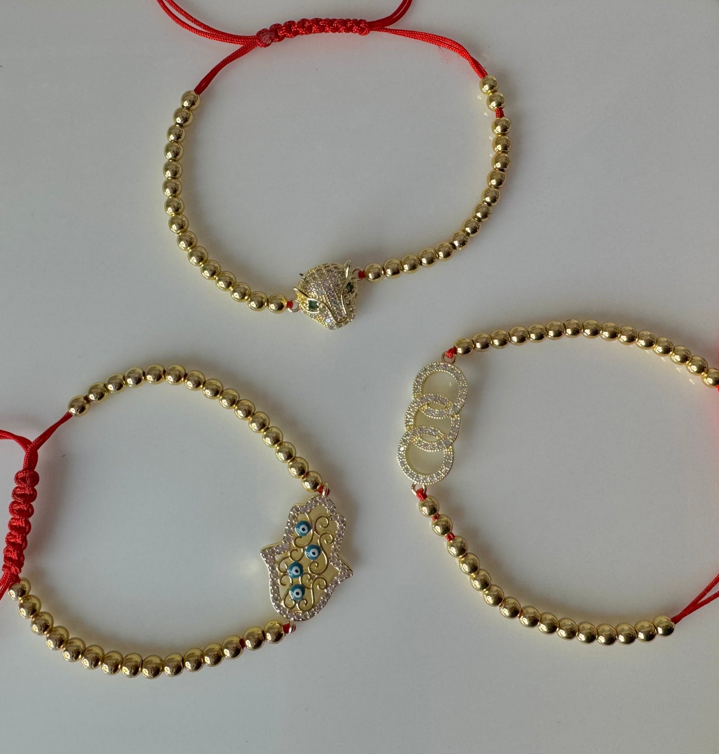 MANILLA DE PERLAS DORADAS CON HILO ROJO
