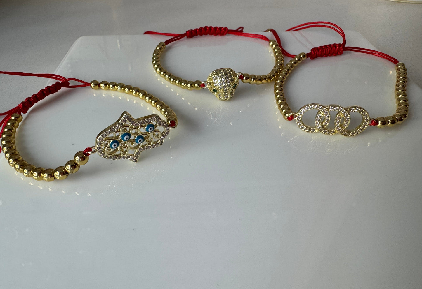 MANILLA DE PERLAS DORADAS CON HILO ROJO