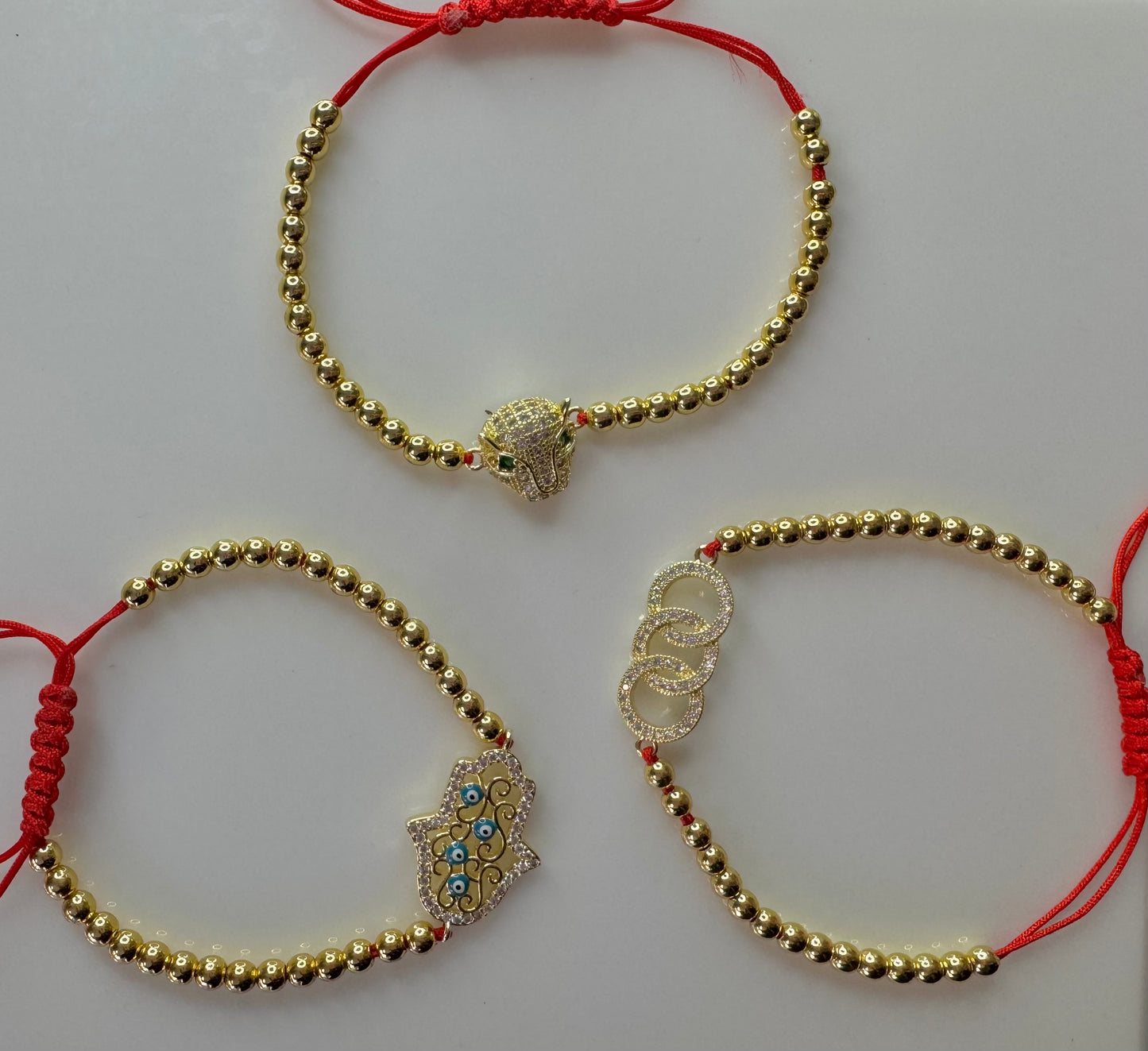 MANILLA DE PERLAS DORADAS CON HILO ROJO